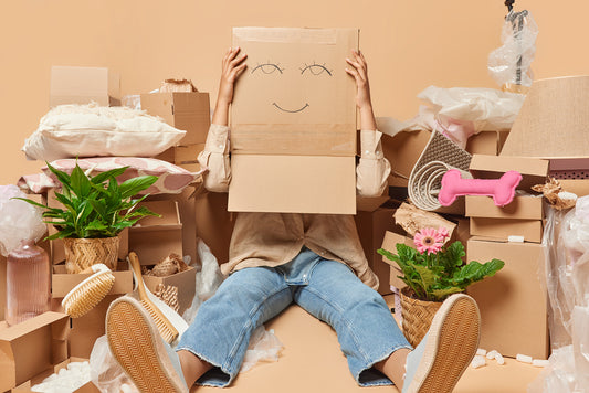Student or young person with box on head and all their belongings around wanting to know what will happen about their storage during vacations time.